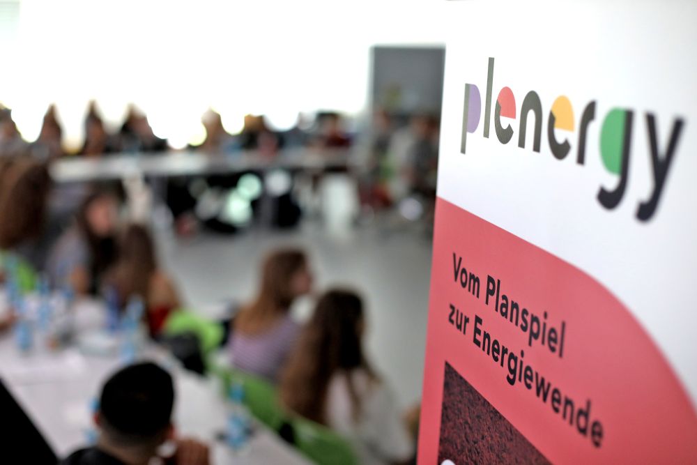 © Klimaschutzagentur Region Hannover/Florian Arp Jugendliche bei einer Veranstaltung, Schriftzug "plenergy" im Vordergrund