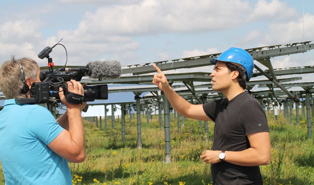 © Energiewende schaffen / WILA Bonn Mann mit Helm vor Solaranlage wird gefilmt