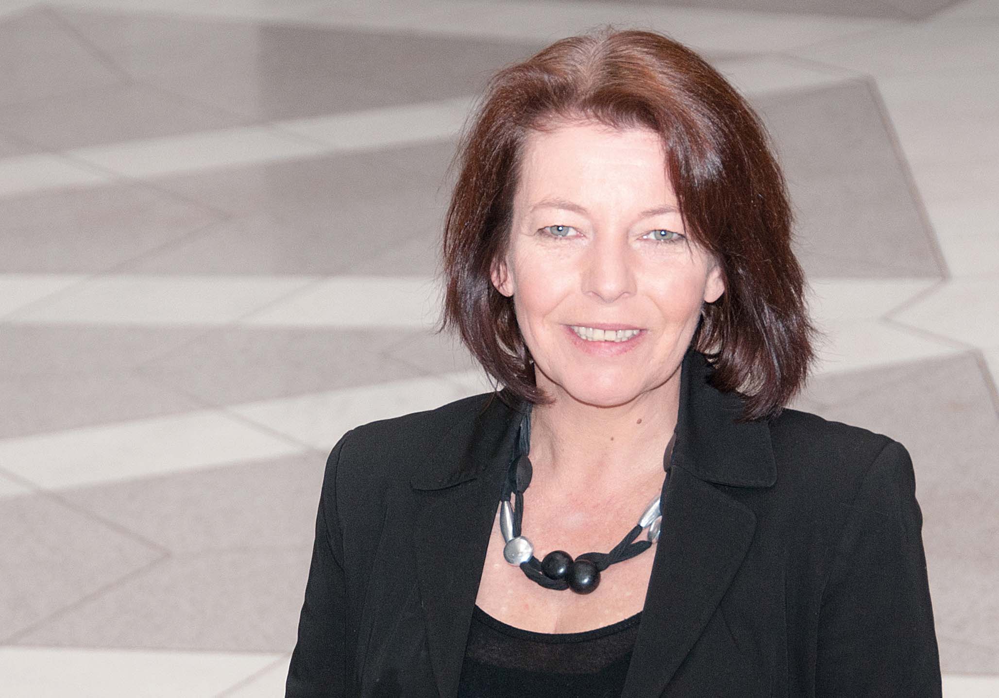 © BIBB Frau im schwarzen Blazer lächelt