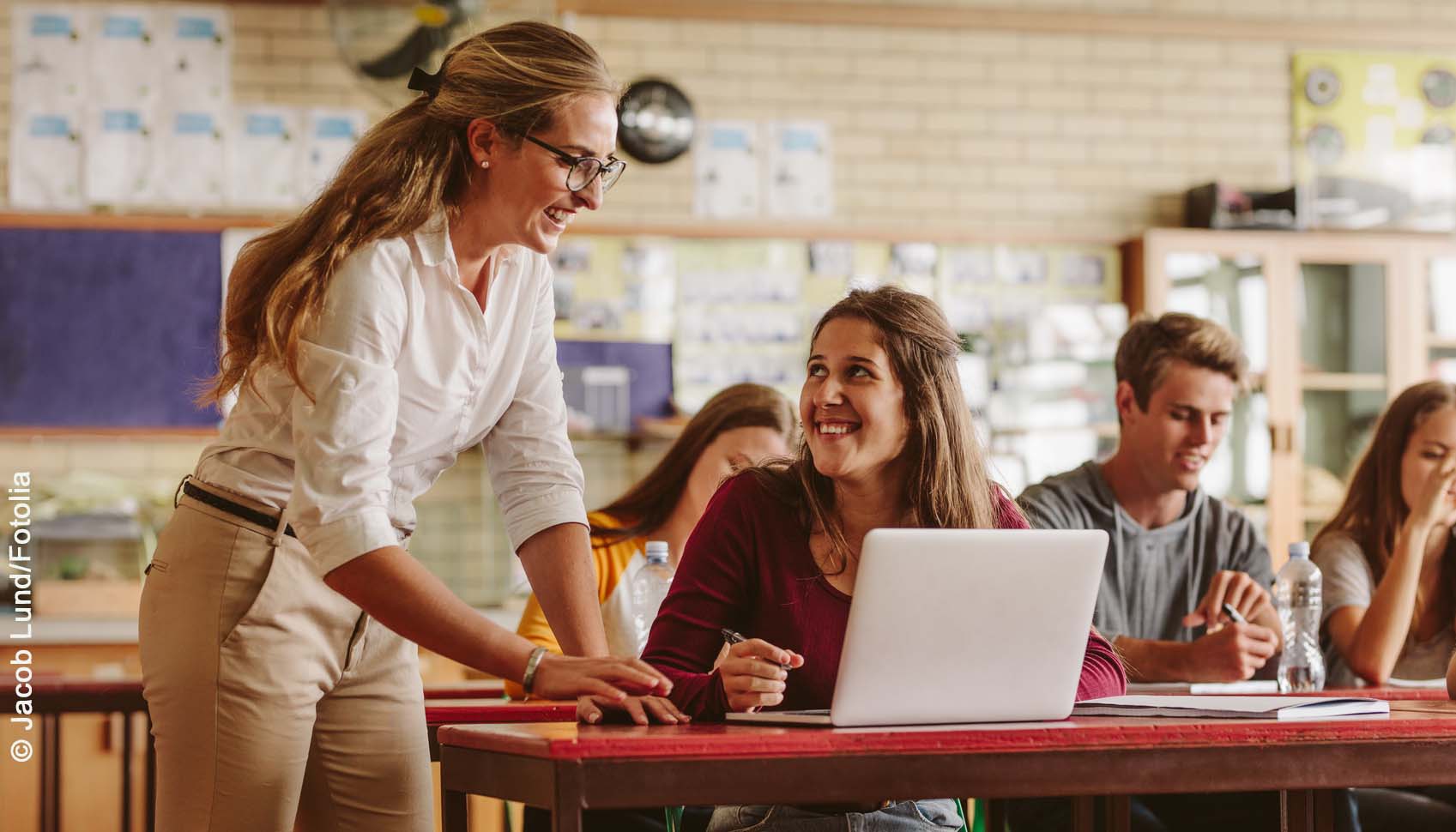 Lehrerin hilft Schülerin am Laptop