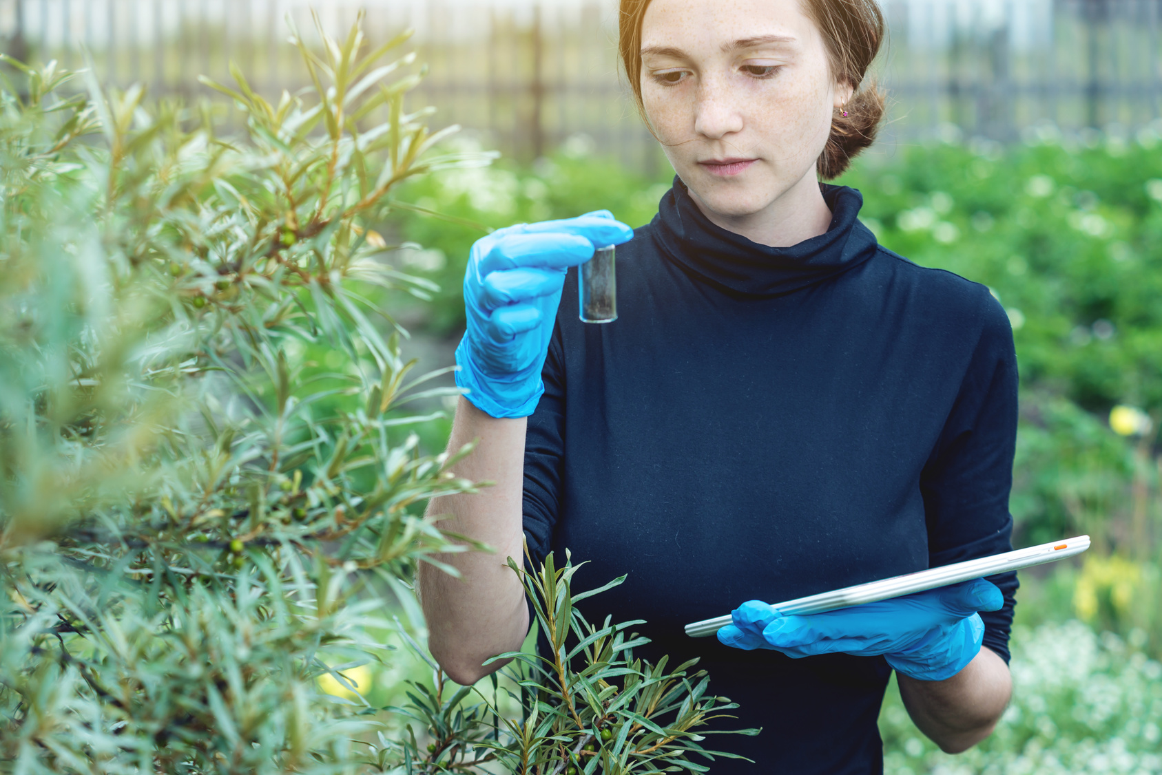 © Artem/Fotolia Frau im Grünen mit Reagenzglas