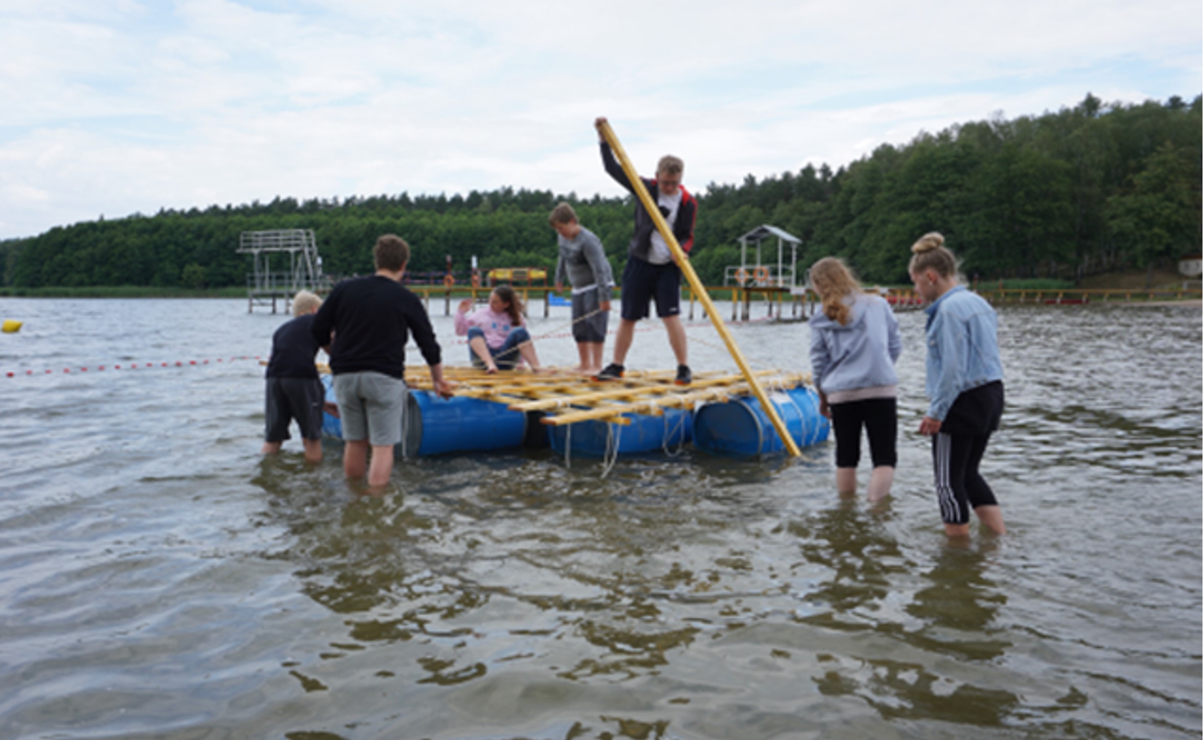 © Angermünder Bildungswerk e. V. 2019 Jugendliche auf und neben einem Floß im Wasser