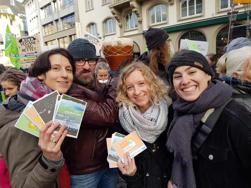 © Grüner Strom Label e.V. drei Frauen halten Postkarten vom Grüner Strom Label und Gas Label hoch