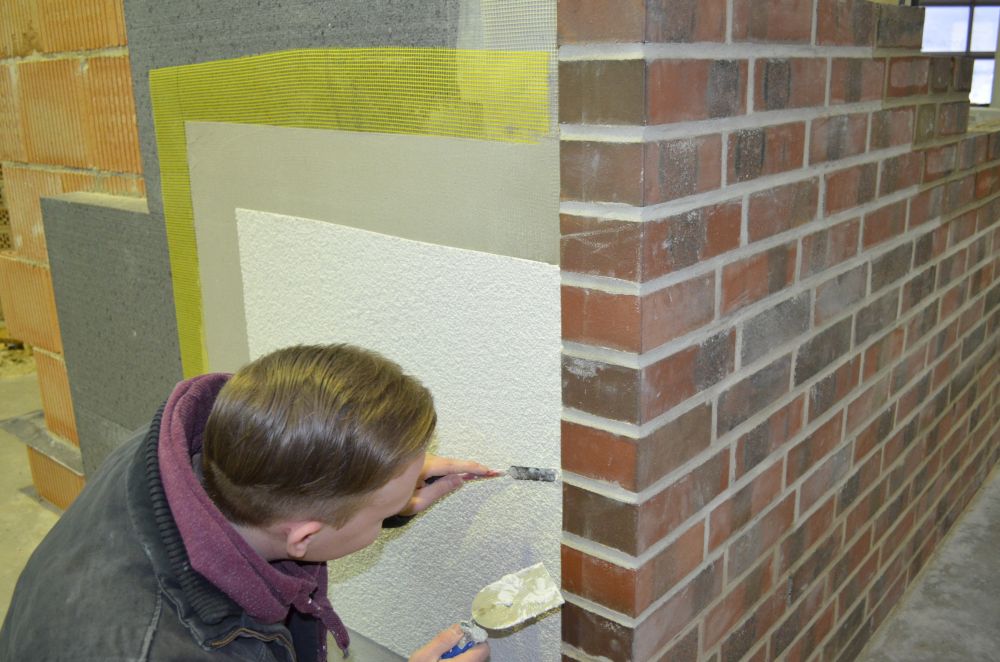 © HBZ Brackwede Maurer beim Verputzen einer Wand