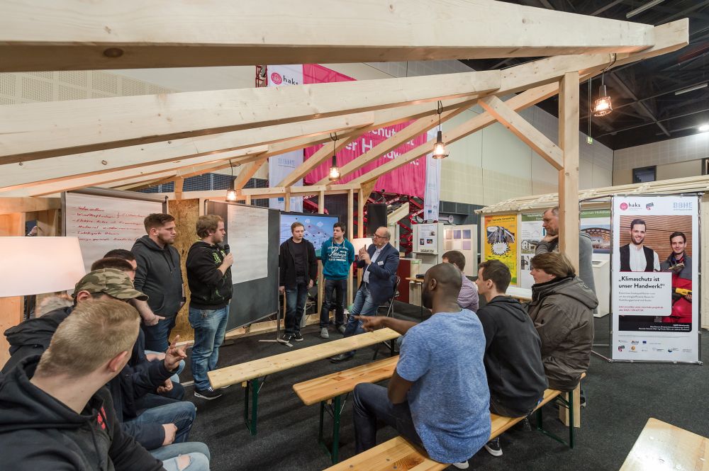© energiekonsens Auszubildende bei einem Seminar unter einem Holzgerüst