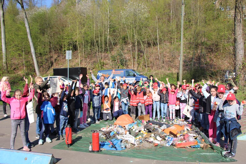 © bochumbolzt Gruppe von Jugendlichen vor gesammeltem Müll