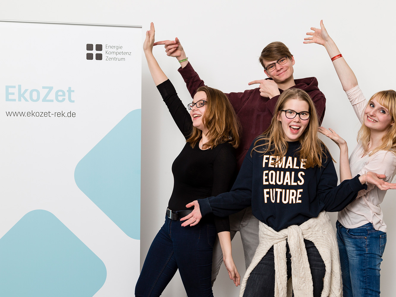 © EkoZet drei Mädchen und ein Junge zeigen auf ein Schild mit der Aufschrift EkoZet
